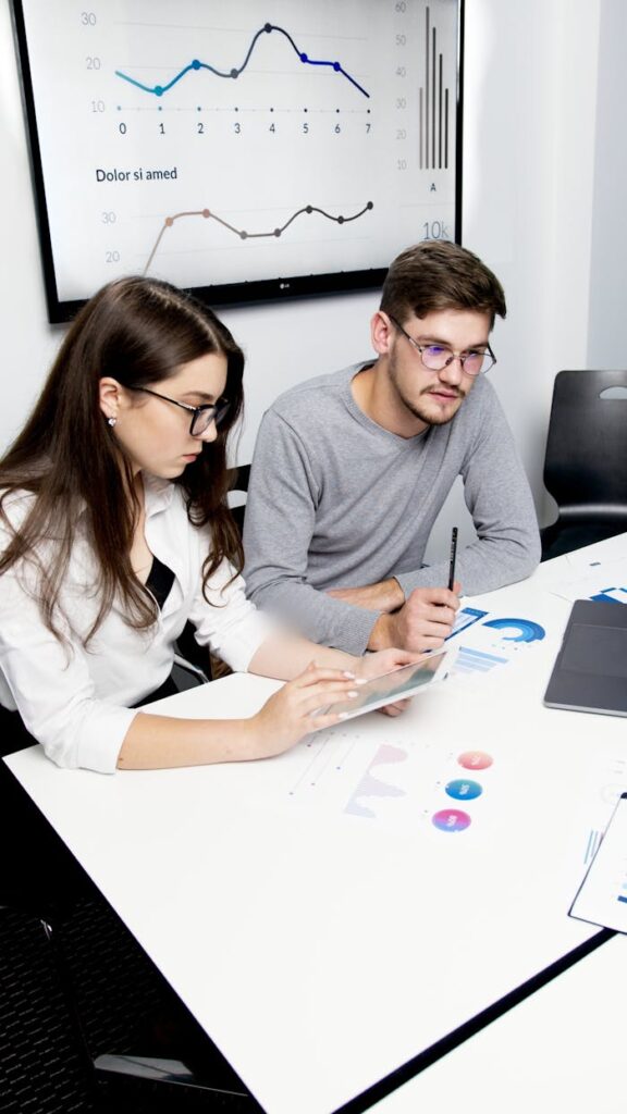 Two business professionals collaborating on financial analysis with charts and graphs.